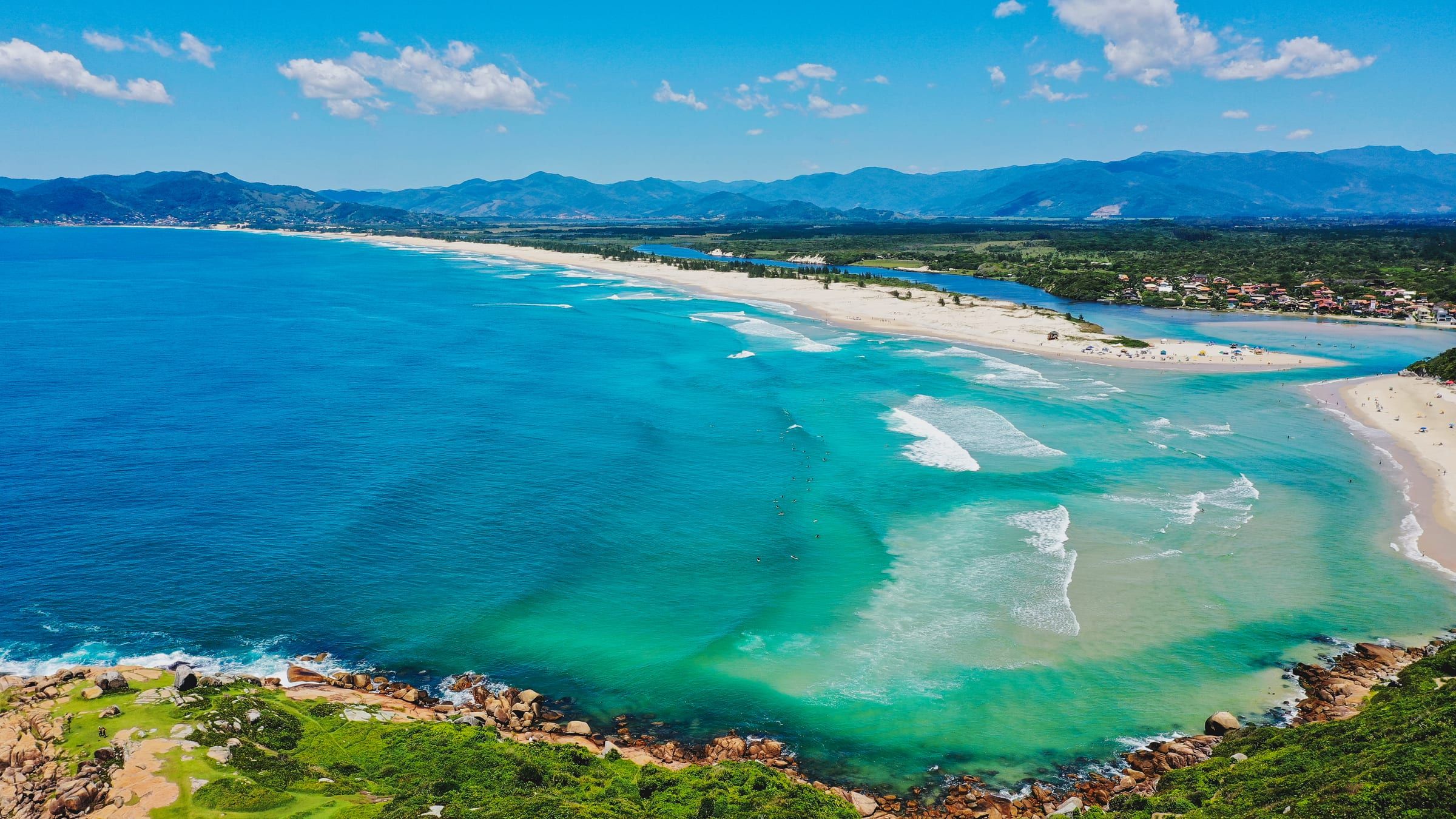 Vista aérea da Guarda do Embaú: o mar, a praia, o rio e os morros ao fundo